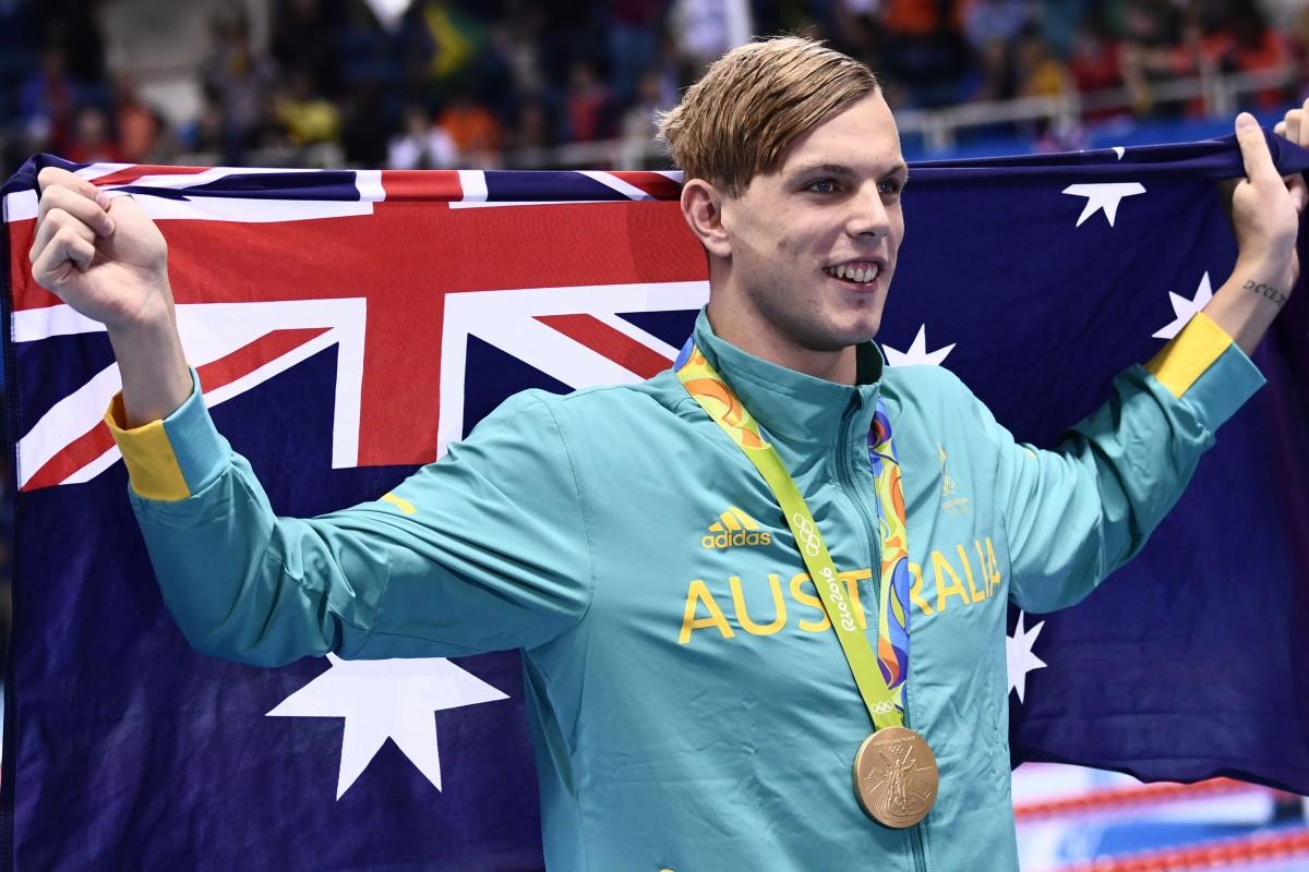 O jovem nadador Kyle Chalmers comemora a medalha de ouro com a bandeira australiana (Christophe Simon/France Press)