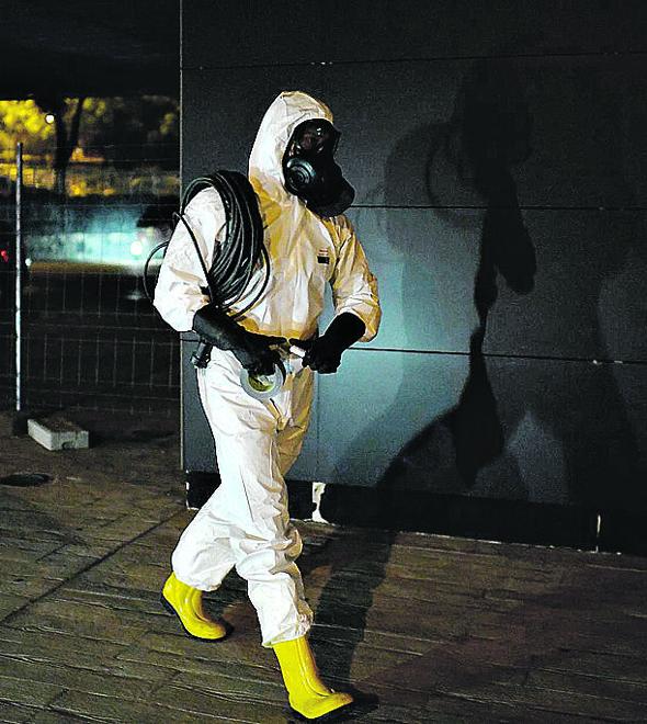 Membro de brigada militar de emergência faz desinfecção noturna em Madri: restrições à mobilidade (Oscar Del Pozo/AFP)