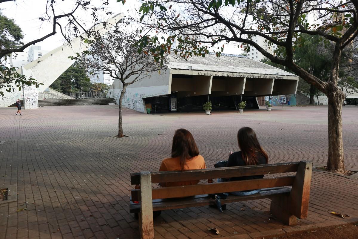 Jovens descansam em banco diante do complexo cultural que é referência artística em Campinas, mas que se encontra abandonado: retrato interno é de deterioração acentuada (Leandro Ferreira)