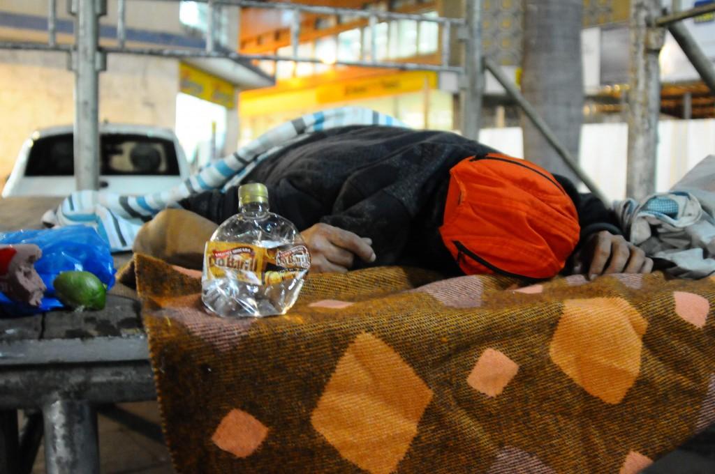 Morador de rua dorme ao lado de garrafa com a mistura de &aacute;lcool combust&iacute;vel na pra&ccedil;a em frente &agrave; Catedral, no Centro (Elcio Alves)