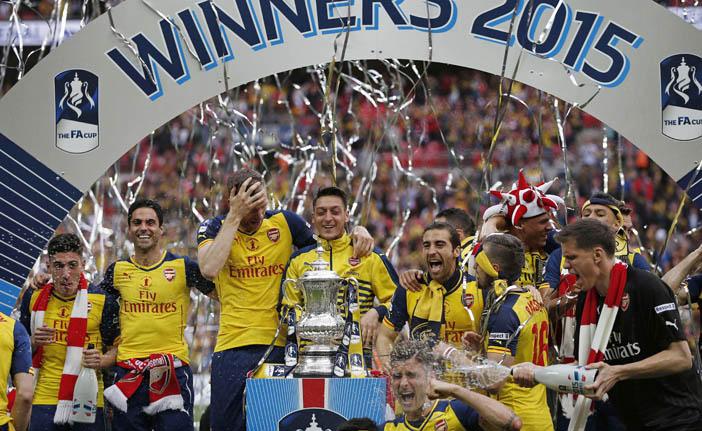 Jogadores do Arsenal festejam o t&iacute;tulo da Copa da Inglaterra, que &eacute; o torneio de futebol mais antigo do mundo (France Press)