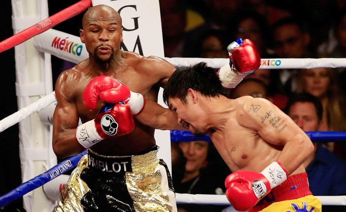 O norte-americano Floyd Mayweather (&agrave; esquerda) vai para as cordas na luta contra o filipino Manny Pacquiao (France Press)