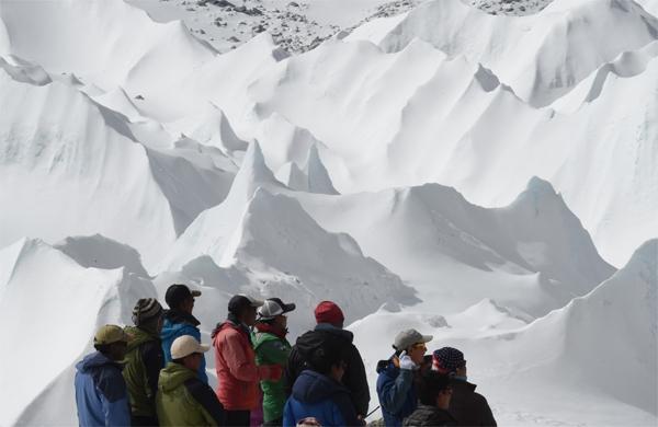 Tursitas ilhados em montanha do Nepal observam helic&oacute;pteros de resgate se aproximar (France Press)