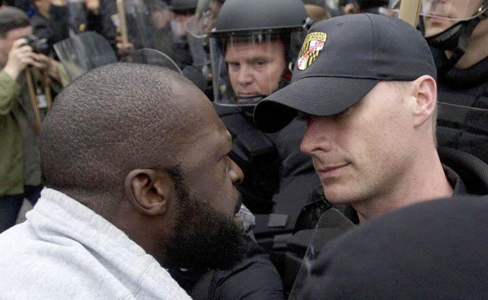 Manifestante encara um policial durante protesto em Baltimore: revolta foi causada pela morte do jovem Freddie Gray na pris&atilde;o (France Press)