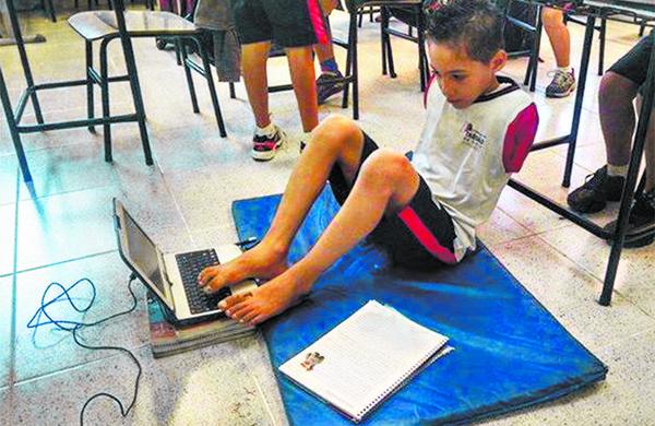 Na escola, Samuel Oliveira utiliza laptop com os p&eacute;s depois de perder bra&ccedil;os em acidente; alegria e supera&ccedil;&atilde;o ( Reprodução)