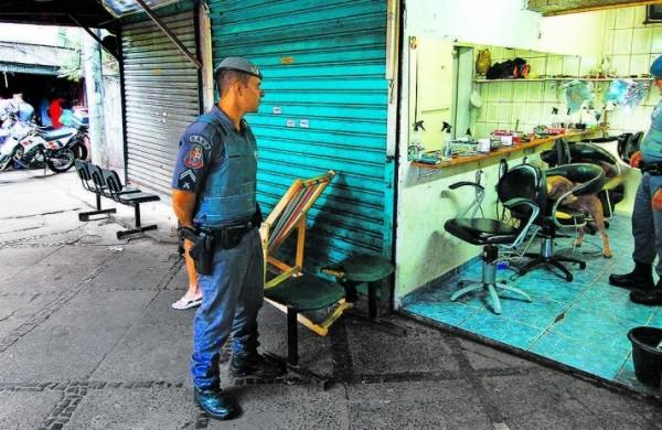 Policiais militares no sal&atilde;o de cabeleireiro onde c&atilde;es farejadores encontraram papelotes de maconha escondidos em cadeira; propriet&aacute;rio foi preso (Janaína Ribeiro/Especial para a AAN)