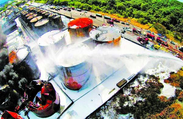 Ap&oacute;s controlar o fogo nesta quinta, bombeiros fizeram o resfriamento de tanques em Santos: combate aos focos se mant&eacute;m (Diego Lameiro/ Divulgação/ Corpo de Bombeiros)