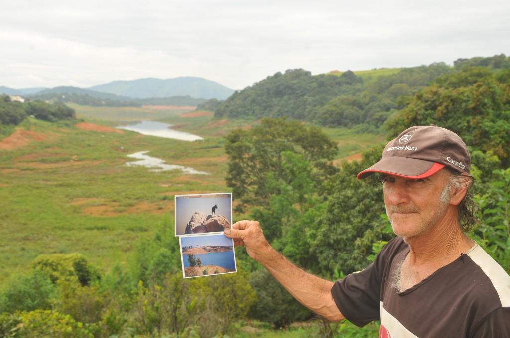 Moacir Bueno de Souza compara a atual paisagem da represa de Vargem, com a antiga, na foto em que segura ( César Rodrigues/ AAN)