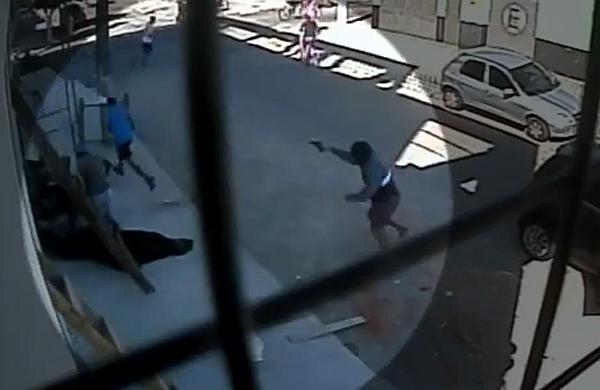 As c&acirc;meras registraram o momento que um comerciante &eacute; perseguido por um homem armado e atingido por sete tiros  (Captura de vídeo)