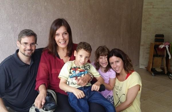 A jornalista Fl&aacute;via Cintra (ao centro, de blusa vermelha), o casal Fabiana e Marcus, e seus filhos adotivos Ra&iacute;ssa e Benjamin, durante as grava&ccedil;&otilde;es de reportagem para o 'Fant&aacute;stico', da Globo ( Divulgação)