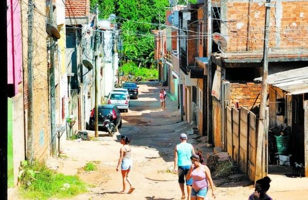 Moradores circulam por rua do bairro, com vegeta&ccedil;&atilde;o nativa ao fundo ( Carlos Sousa Ramos/ AAN)