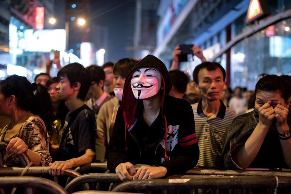 Manifestante pr&oacute;-democracia usa m&aacute;scara em barricada durante um impasse com a pol&iacute;cia em Hong Kong r
 (Alex Ogle/ AFP)