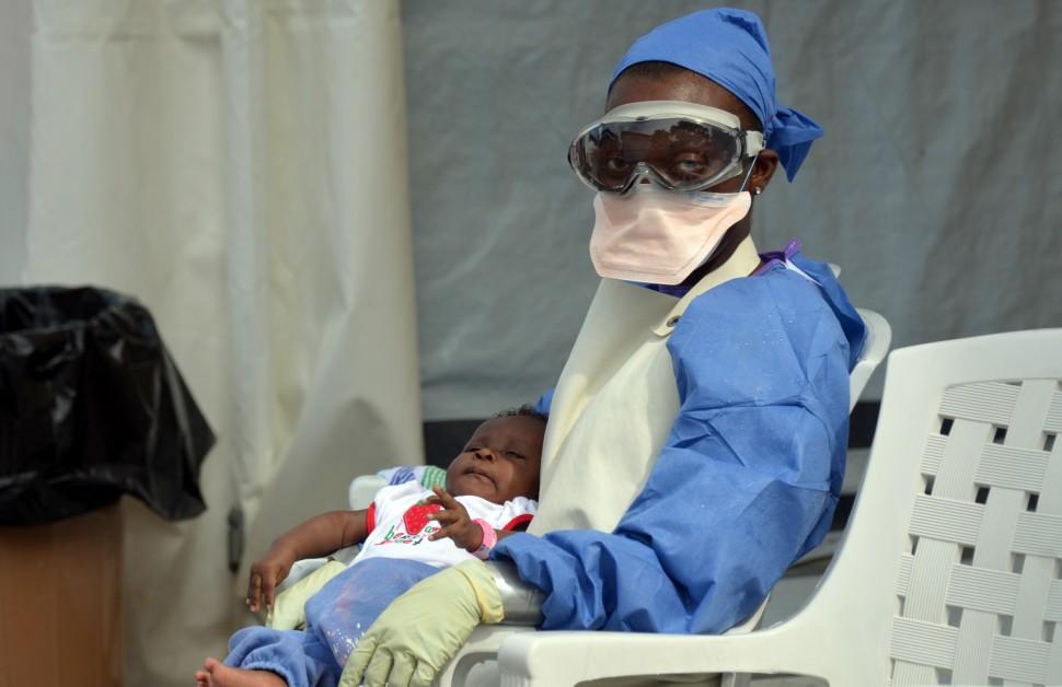 Trabalhador da sa&uacute;de liberiano tem um beb&ecirc; infectado com o v&iacute;rus Ebola em 18 de outubro de 2014, a ONG M&eacute;dicos Sem Fronteiras centro de tratamento de Ebola em Monrovia (AFP)