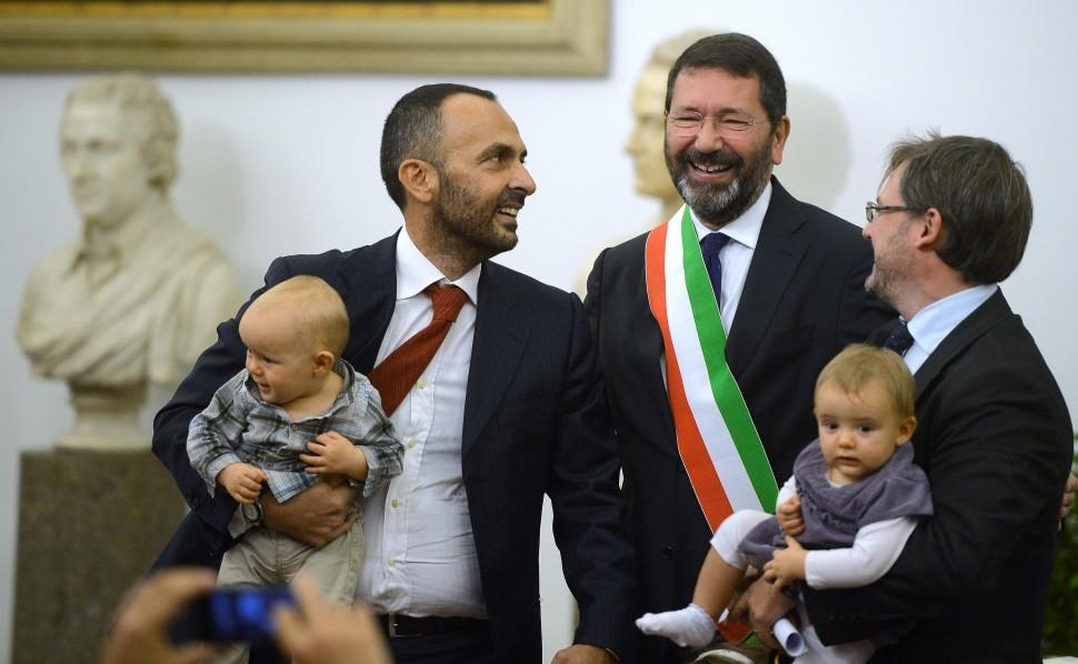 O prefeito de Roma, Ignazio Marino (no centro), posa com um casal gay depois que ele registra seu casamento na sala de recep&ccedil;&atilde;o da prefeitura de Roma (France Press)