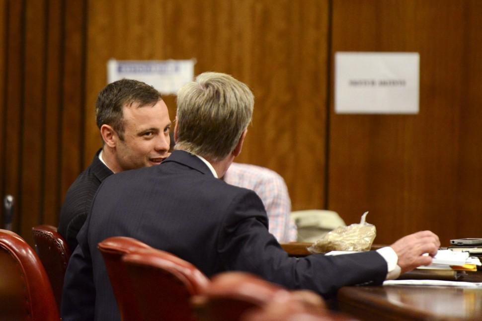 Atleta paraol&iacute;mpico do Sul Africano Oscar Pistorius fala com um de seu advogado de defesa Brian Webber durante sua audi&ecirc;ncia de senten&ccedil;a no Supremo Tribunal em Pret&oacute;ria (Herman Verwey/ AFP)