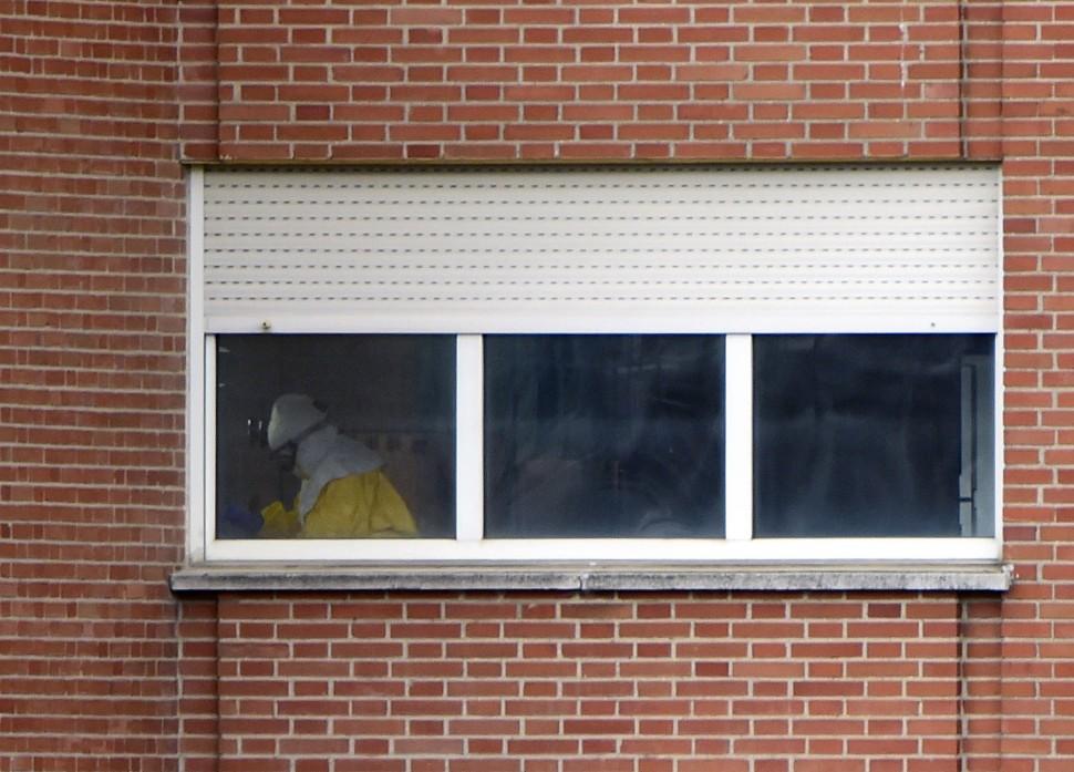 Equipe m&eacute;dica vestindo roupas de prote&ccedil;&atilde;o trabalham em &aacute;rea de quarentena no sexto andar do hospital Carlos III, em Madrid  (Pierre-Philippe Marcou/ AFP)