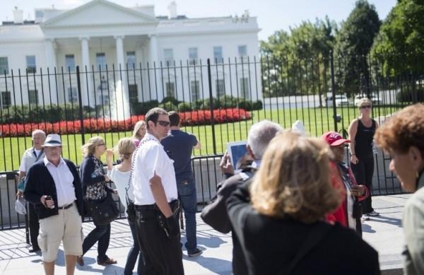 Membro das patrulhas Servi&ccedil;o Secreto dos EUA vigiam o lado de fora de uma cerca tempor&aacute;ria instalada na Casa Branca, em Washington (France Press)