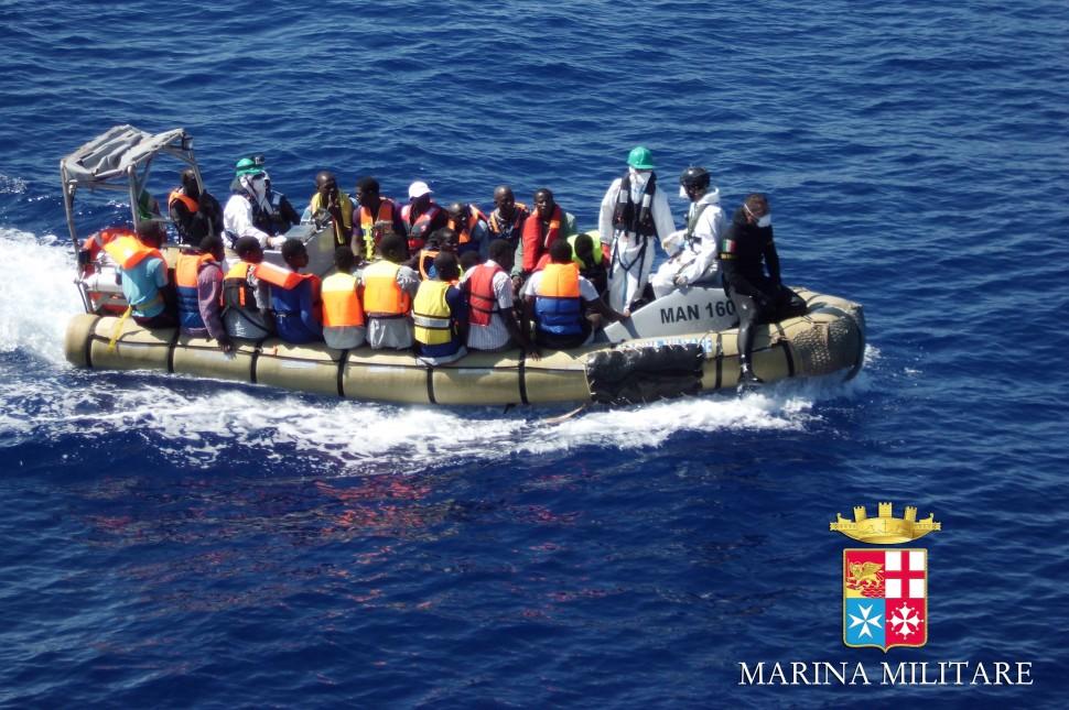 Imagem divulgada pela Marinha italiana mostra migrantes sentados em um barco durante uma opera&ccedil;&atilde;o de resgate na costa da Sic&iacute;lia (AFP)