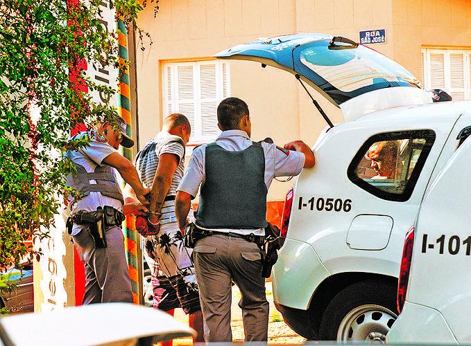 Policiais militares conduzem um dos detidos para o plant&atilde;o  ( Del Rodrigues/ AAN)