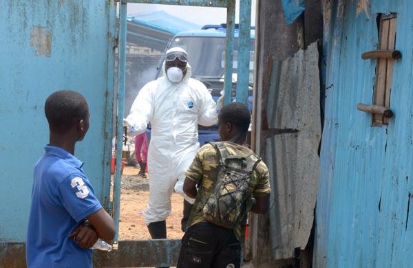Parentes de pessoas infectadas esperar por not&iacute;cias na entrada da &aacute;rea de alto risco no hospital John Fitzgerald Kennedy de Monrovia (AFP)