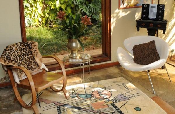 Na casa de Beth Godoy, o efeito das plantas atrav&eacute;s do vidro &eacute; o mesmo, por&eacute;m valorizado pela incorpora&ccedil;&atilde;o de cadeiras ( Divulgação)