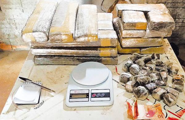 Bloco de anota&ccedil;&otilde;es, balan&ccedil;a de precis&atilde;o, dinheiro, tijolos e por&ccedil;&otilde;es de maconha apreendidos ontem pela PM (Baep/ Divulgação)