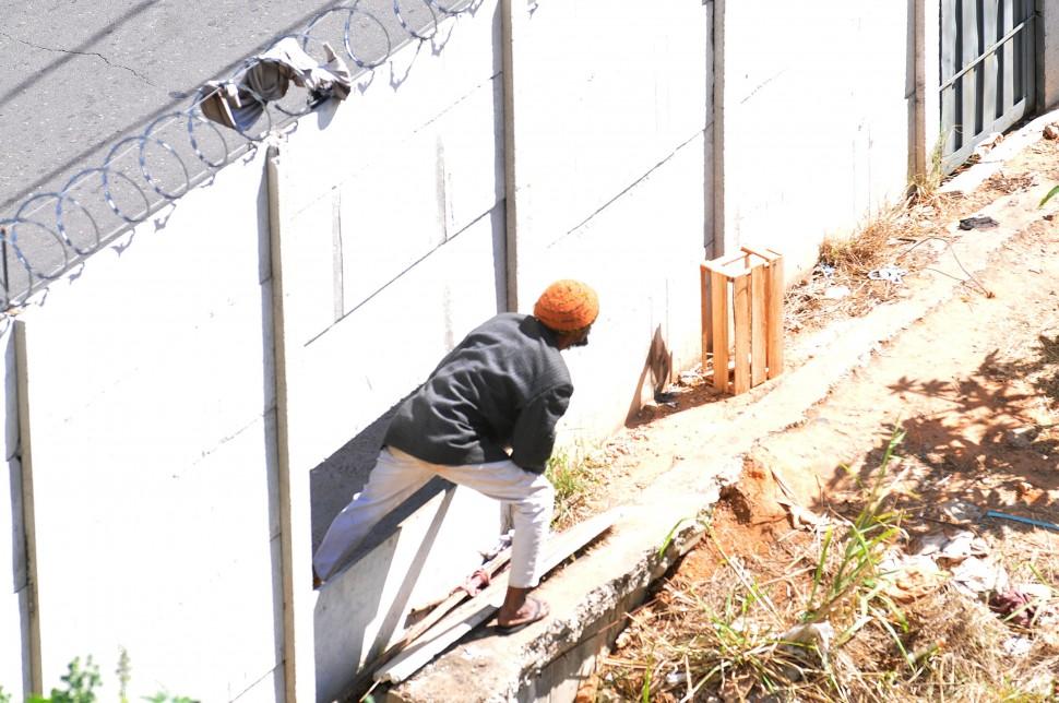 Pessoas invadem o terreno abandono atrav&eacute;s de buracos que h&aacute; no muro ( Carlos Sousa Ramos/ AAN)