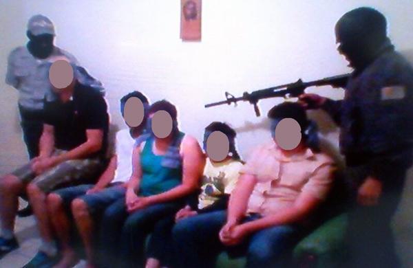Foto enviada por sequestradores mostra fam&iacute;lia sob a mira dos bandidos (Reprodução/Polícia Civil)