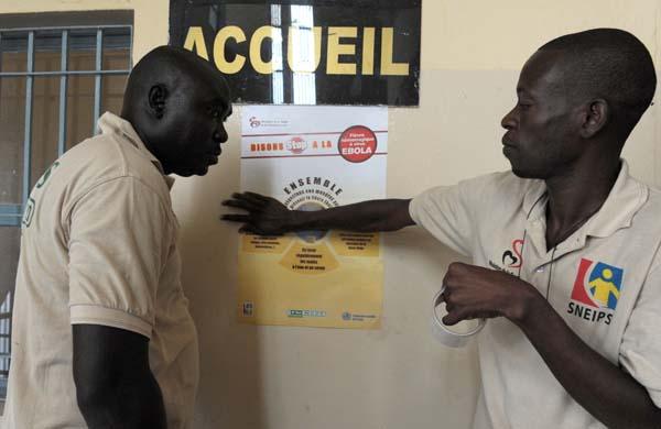 Trabalhadores senegaleses trabalham colando posteres e orientando a popula&ccedil;&atilde;o (France Press)