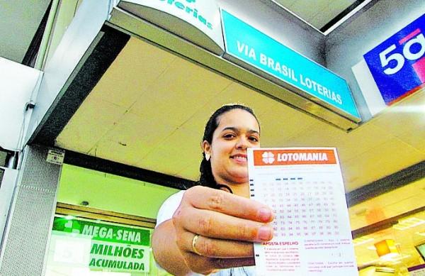 A gerente Yasmim da Silva, da Via Brasil Loterias, onde o jogo foi feito, mostra o volante da Lotomania  (Jaqueline Harumi/AAN )