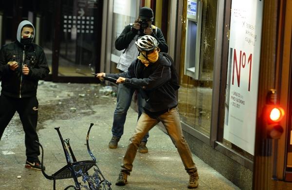 Manifestante espanhol quebra o vidro de um banco durante protesto em Madri (France Press)