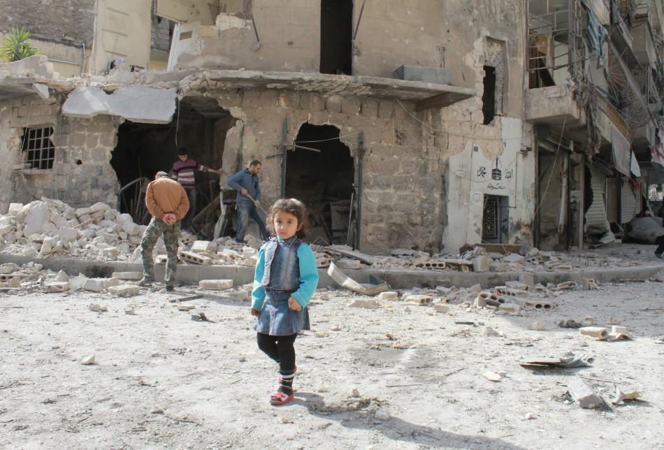 Menina s&iacute;ria caminha em rua na cidade s&iacute;ria de Aleppo ap&oacute;s um ataque a&eacute;reo das for&ccedil;as governamentais  (AFP)
