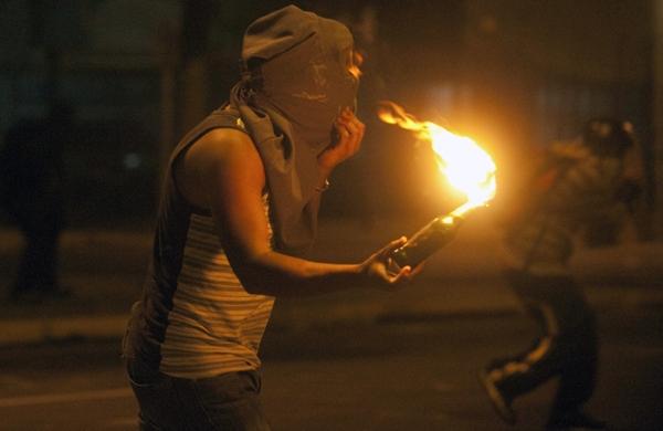 Manifestante venezuelano com coquetel molotov durante protesto (France Press)