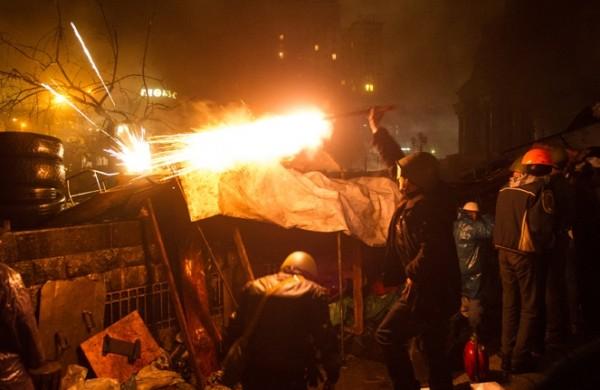 Manifestante ucraniano atira fogos de artificio contra policiais durante protesto (France Press)