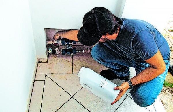 Funcion&aacute;rio p&uacute;blico checa condi&ccedil;&otilde;es de hidr&ocirc;metro em casa de Amparo ( Divulgação)