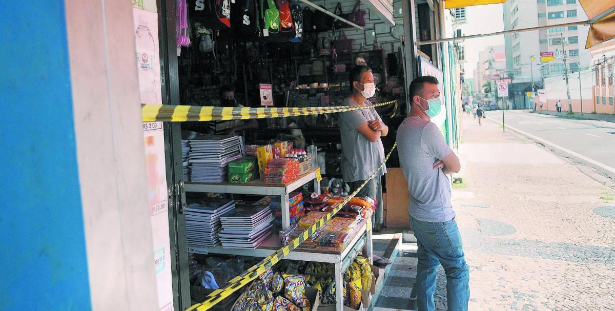 No Centro, loja de miudezas com a porta semiaberta expõe bolachas e salgadinhos junto com mercadorias não essenciais: “jeitinho” para consegir ludibriar a fiscalização  (Diogo Zacarias/ Correio Popular)
