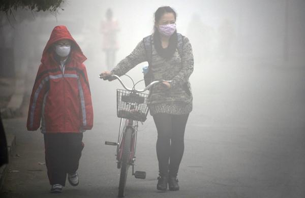 Chineses se protegem com máscaras contra poluição que tomou a cidade (France Press)