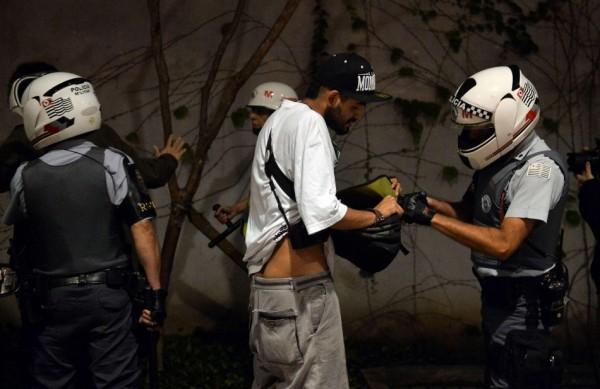 Policial faz revista durante protesto na Capital; Alckmin garantiu que em São Paulo não haverá uso de arma letal (France Press)