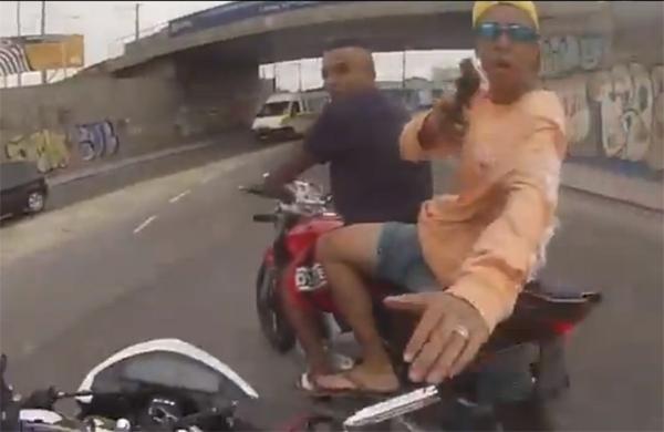 Momento em que bandido aborda motociclista com arma em punho ( Reprodução)