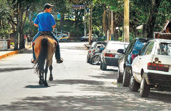 Morador passeia a cavalo em rua da cidade, reforçando clima rural (Elcio Alves/AAN)