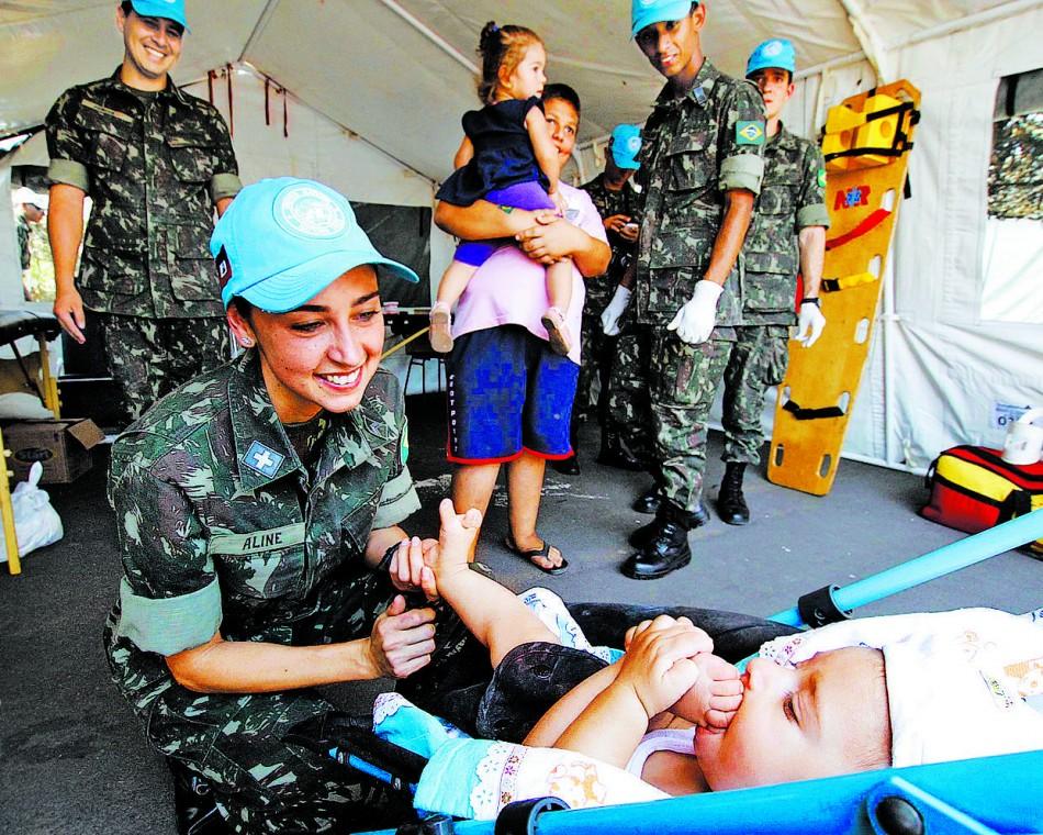 A sargento Aline observa bebê em tenda de atendimento montada na Praça João Amazonas: "Meninas me abordaram interessadas na carreira"  ( Edu Fortes/AAN)