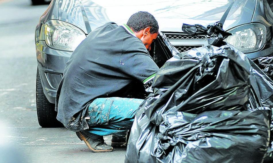 Homem procura comida em sacos de lixo na Rua César Bierrembach, no Centro: ?A gente perde a vergonha? (Érica Dezonne/AAN)