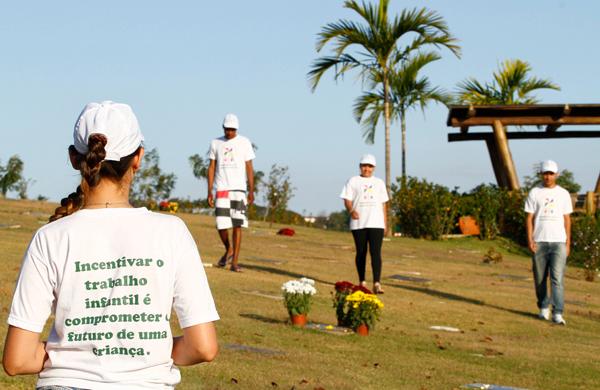 Voluntários durante ação no Cemitério Flamboyant, em Campinas: faixas e panfletos alertam visitantes para não financiar trabalho infantil ( Gustavo Tilio/Especial para a AAN)