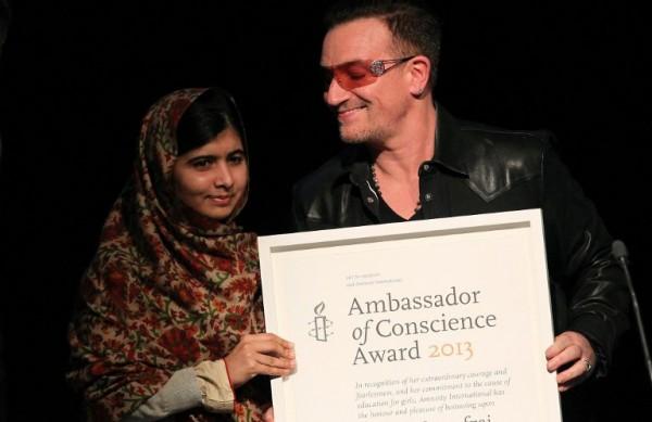 A adolescente paquistanesa Malala recebe um certificado da Anistia Internacional, entregue pelo vocalista da banda U2, Bono (France Press)