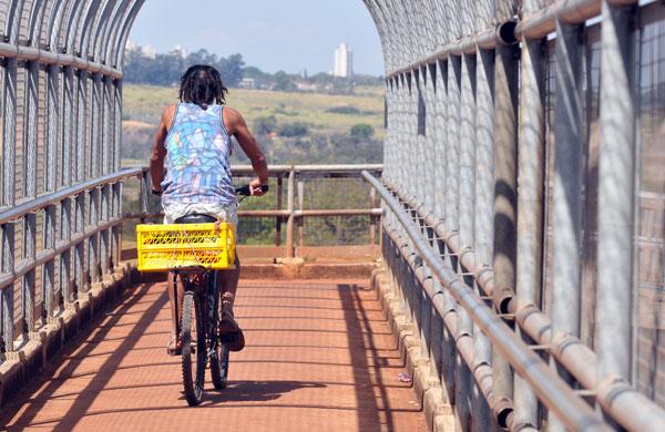 Homem passando sobre passarela da Rodovia Dom Pedro de bicicleta (Dominique Torquato/AAN)