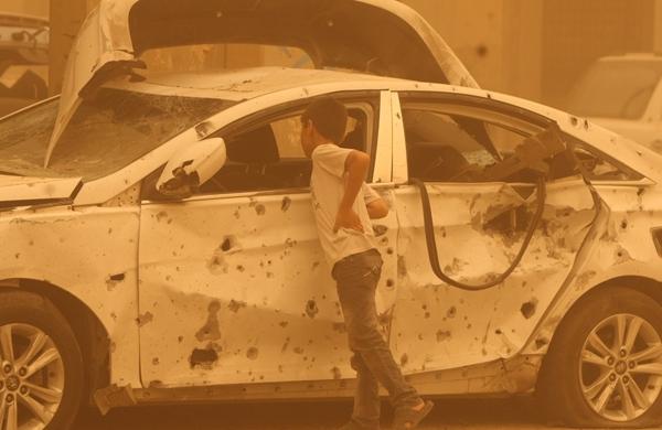 Garoto observa carro bomba após explosão em frente à mesquita (France Press)