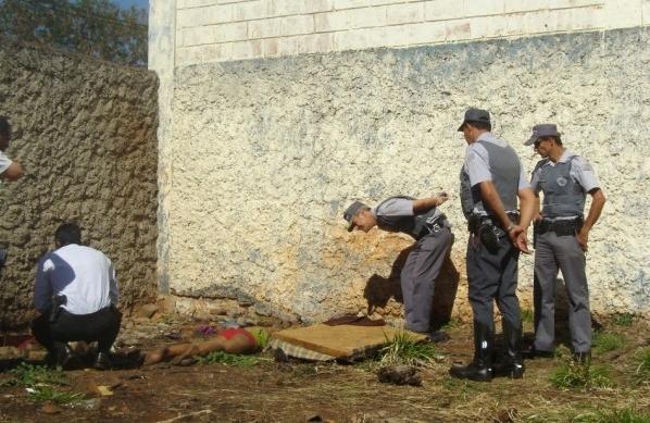 Policiais civis e militares observam o corpo da jovem que foi morta (Luís Augusto/AAN)
