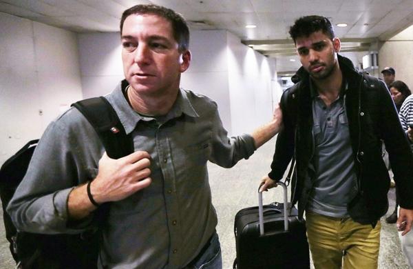 Glenn Greenwald (E) acompanha David Miranda (D) em desembarque no aeroporto do Rio de Janeiro (France Press)