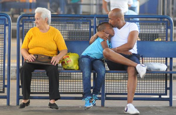 Pai demosntra carinho pelo filho, enquanto espera por ônibus (Érica Dezonne/AAN)
