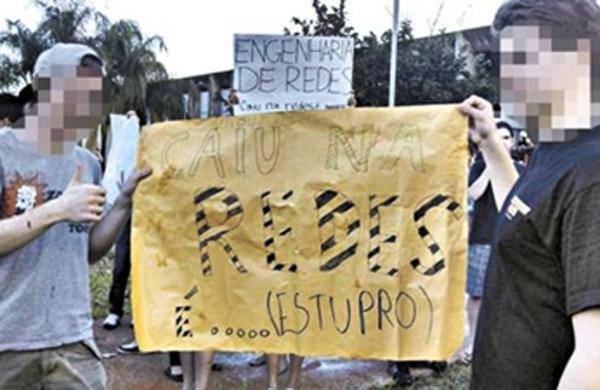 Alunos seguram o cartaz com os dizeres ofensivos durante a divulgação dos aprovados no 2º vestibular de 2013 ( Divulgação)